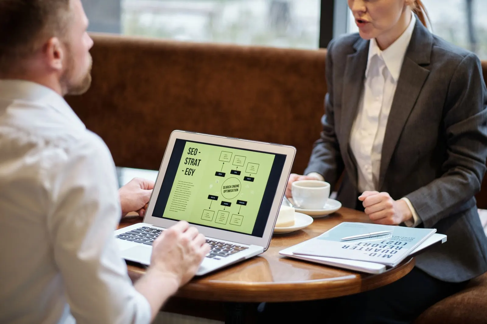 Two people in a working meeting reviewing strategy on a laptop — the kind of honest SEO conversation this post argues you should be having
