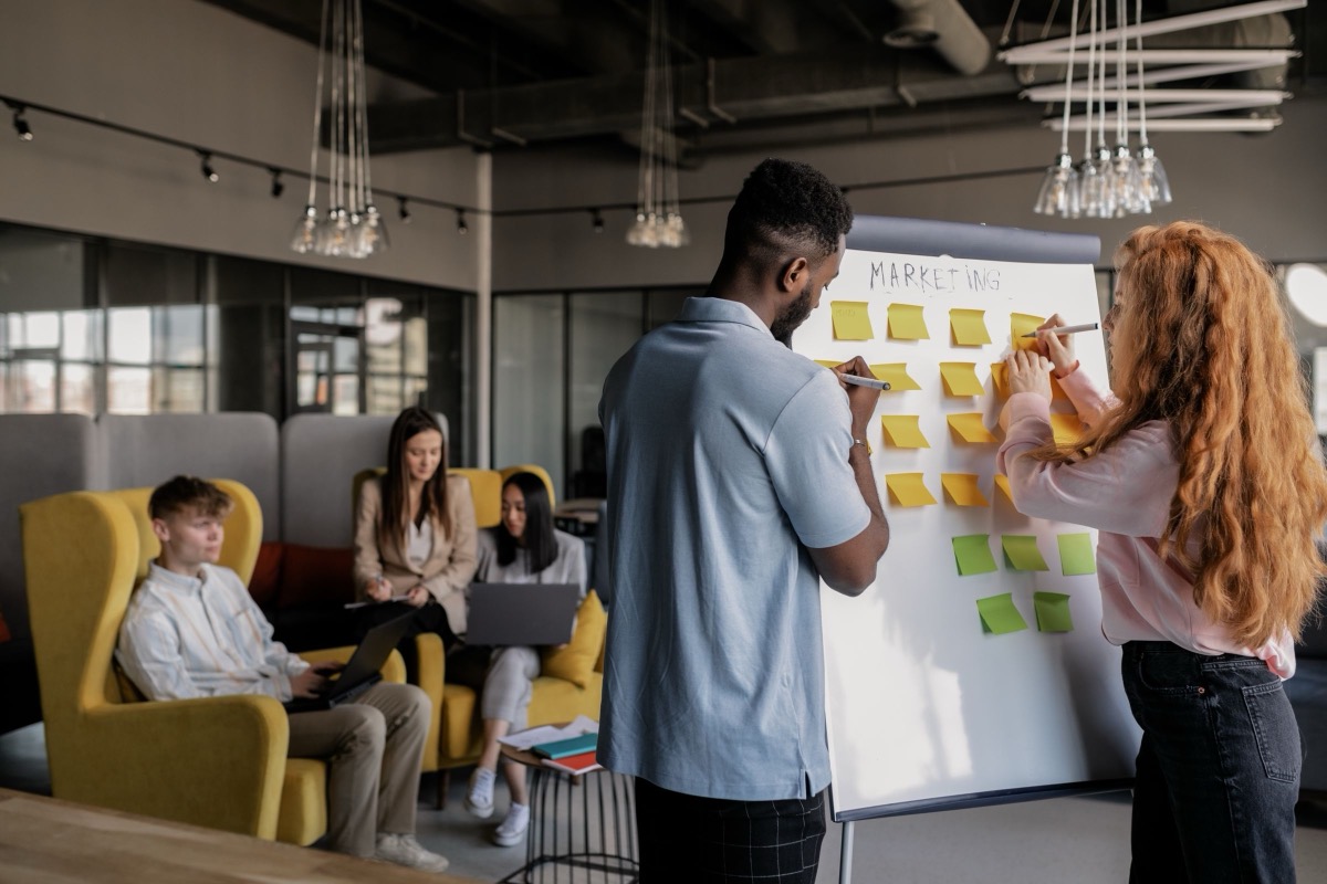 A small team planning with sticky notes on a whiteboard