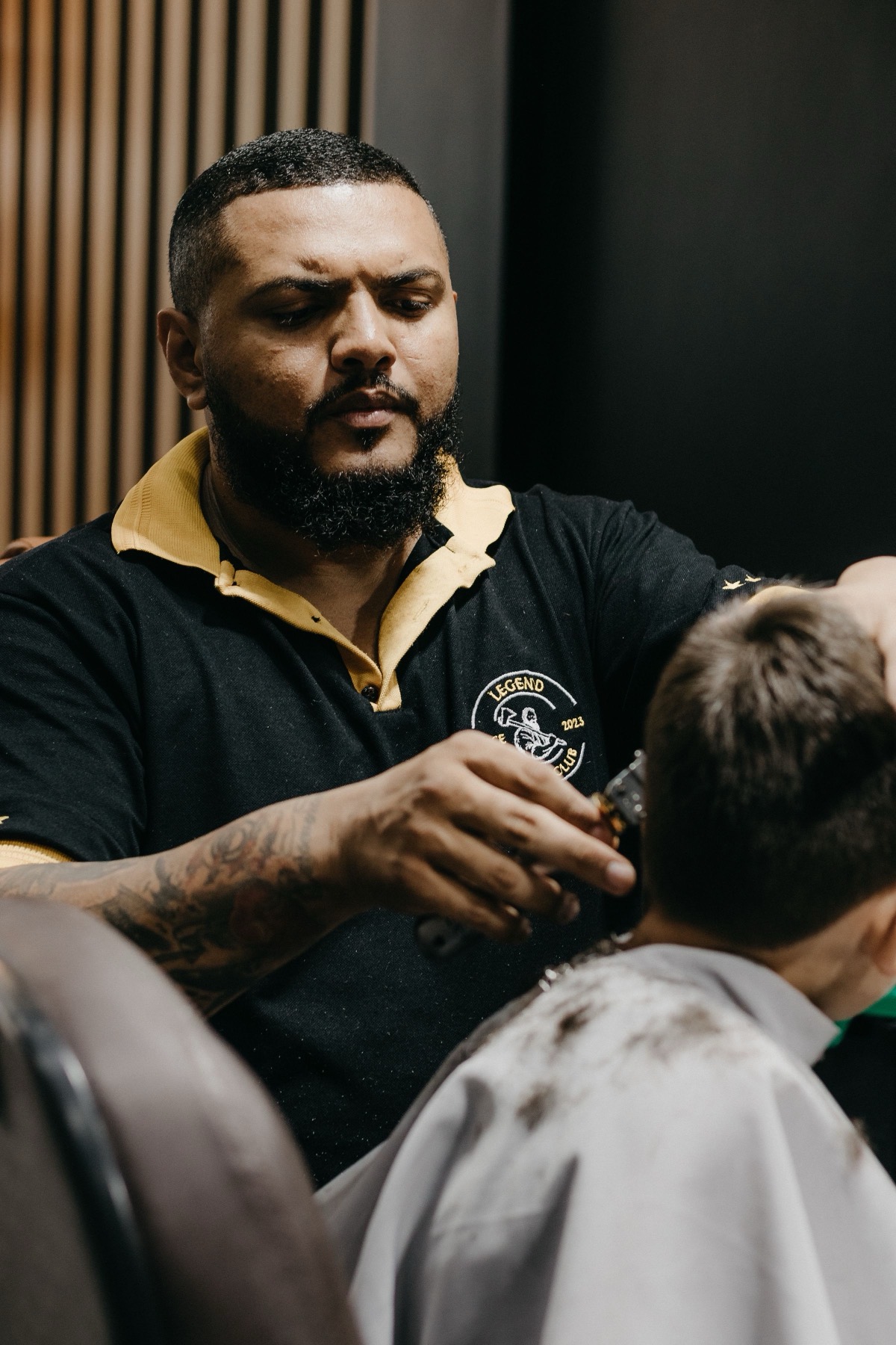A barber cutting a young client's hair