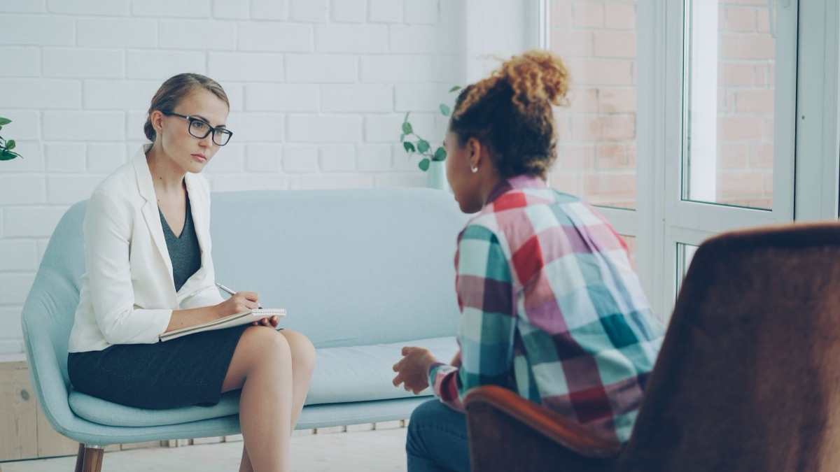 A counsellor listening to a client in a calm, bright room