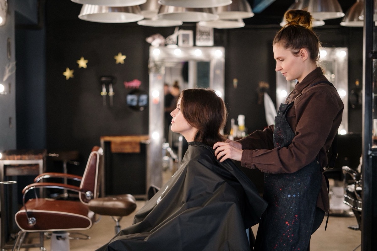 A hair stylist checking a client's cut in a salon
