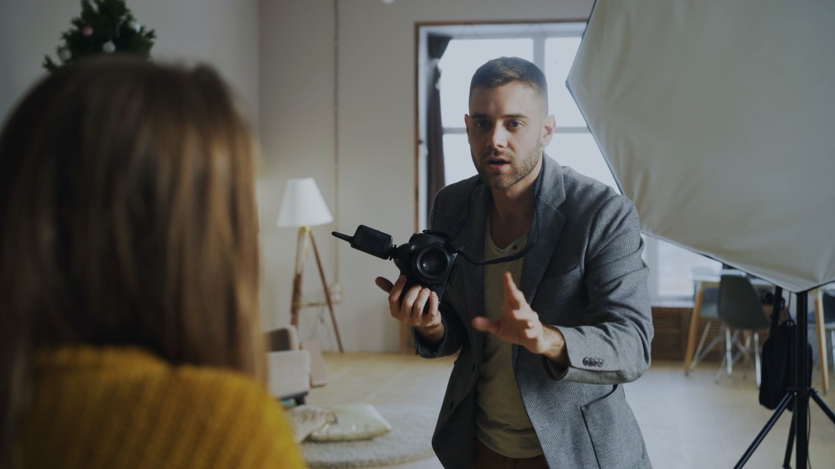 A photographer directing a portrait session in a studio